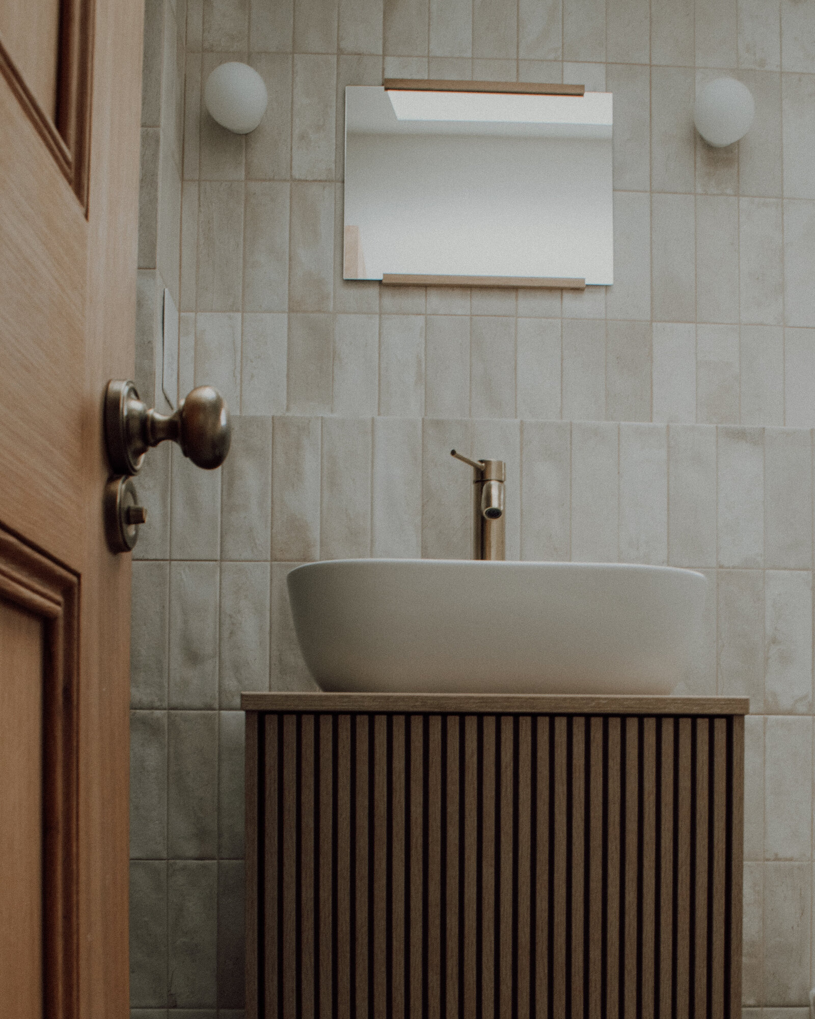 Cheltenham: a stone-tiled basin with a fluted timber vanity